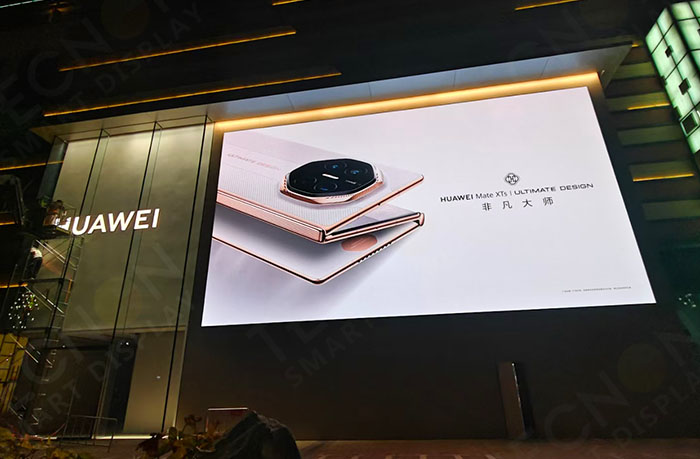 LED screen playing Huawei promotional video at night