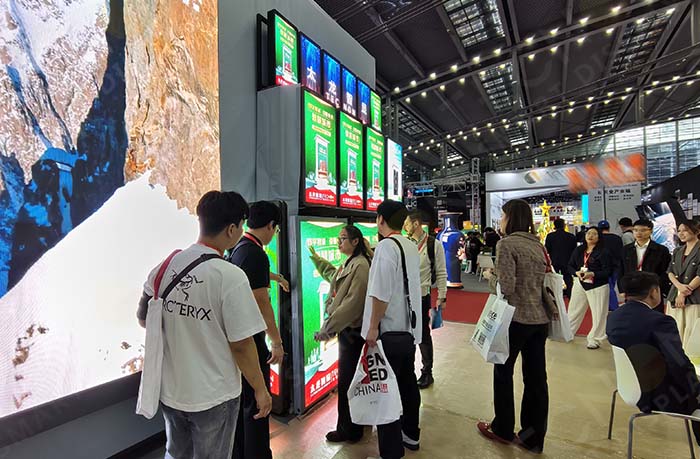 Sales staff introducing LED pole screen to visitors at the exhibition booth
